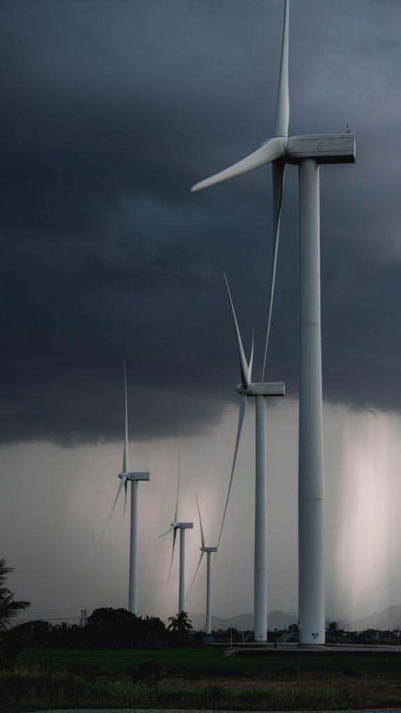 white wind turbine under gray sky